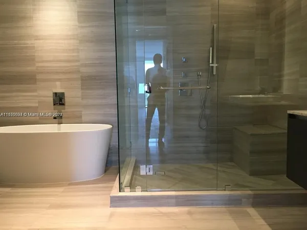 a white tub sitting next to a shower