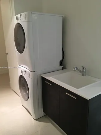 a utility room with sink dryer and washer