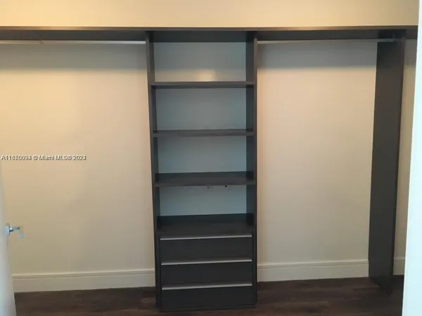 a view of walk in closet with empty racks