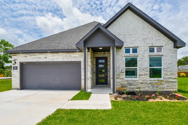 a front view of a house with a yard and garage