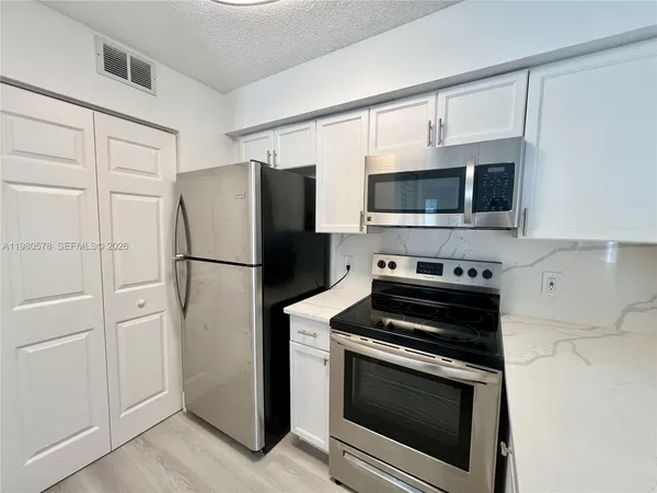 a kitchen with cabinets and stainless steel appliances
