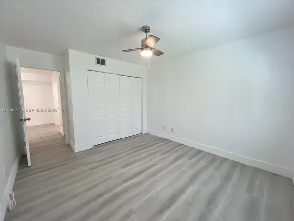 a view of empty room with wooden floor