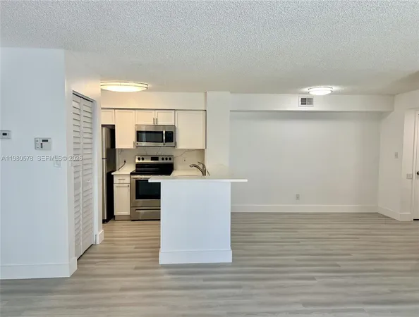a kitchen with granite countertop a refrigerator and a stove