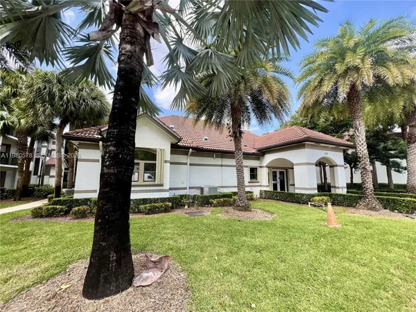 a front view of a house with garden and trees
