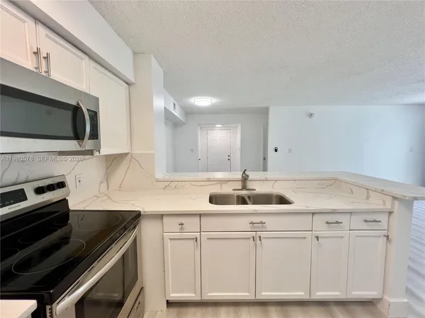 a kitchen with granite countertop a sink and cabinets