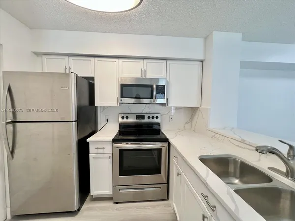 a kitchen with a refrigerator sink and stove