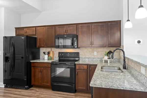 a kitchen with granite countertop stainless steel appliances and wooden cabinets