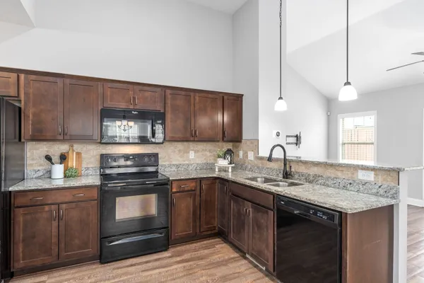 a kitchen with stainless steel appliances granite countertop a sink stove and cabinets