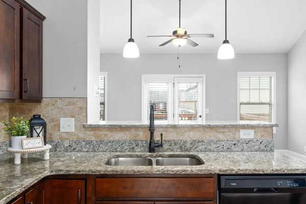 a kitchen with stainless steel appliances granite countertop a sink a window and cabinets