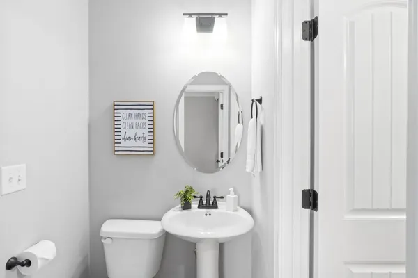 a bathroom with a toilet a sink and mirror