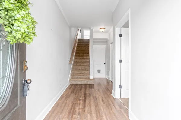 a view of a hallway with wooden floor and entryway