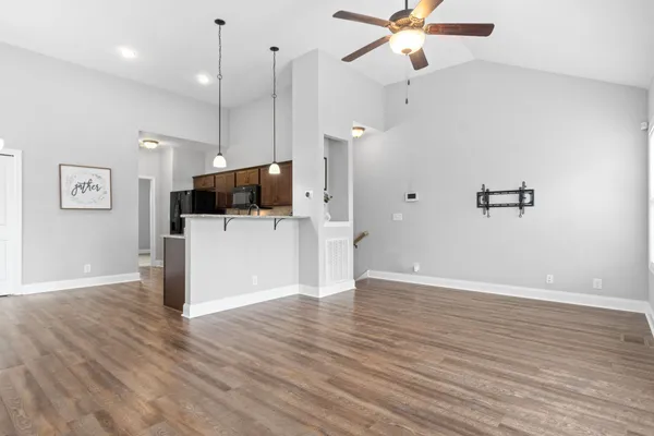 a view of a kitchen with a microwave and wooden floor
