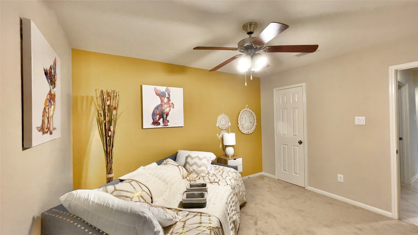 21618 Ivory Gate Lane Katy, TX 77449 - Photo 11 of 32 a bedroom with a bed and a chandelier