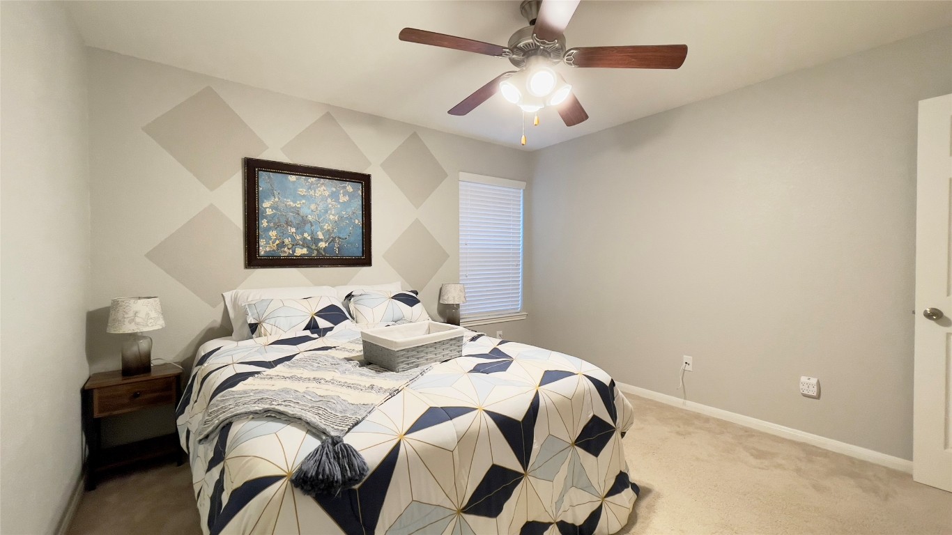 21618 Ivory Gate Lane Katy, TX 77449 - Photo 12 of 32 a bedroom with a bed and a chandelier