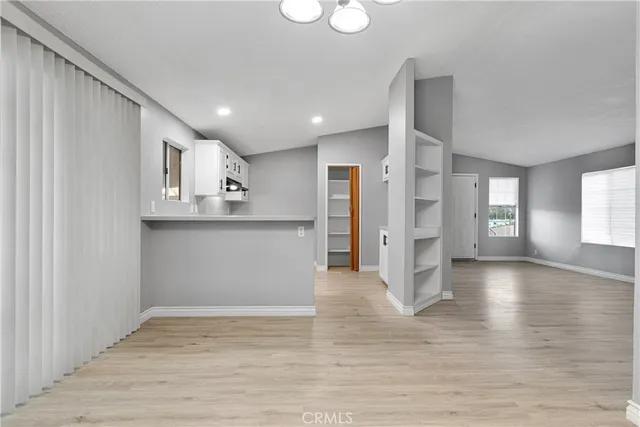 a view of a kitchen with wooden floor and a window