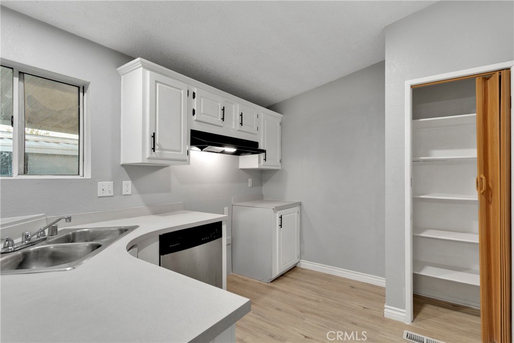 8450 G Avenue, Unit 63 Hesperia, CA 92345 - Photo 14 of 31 a kitchen with stainless steel appliances a sink a stove and white cabinets