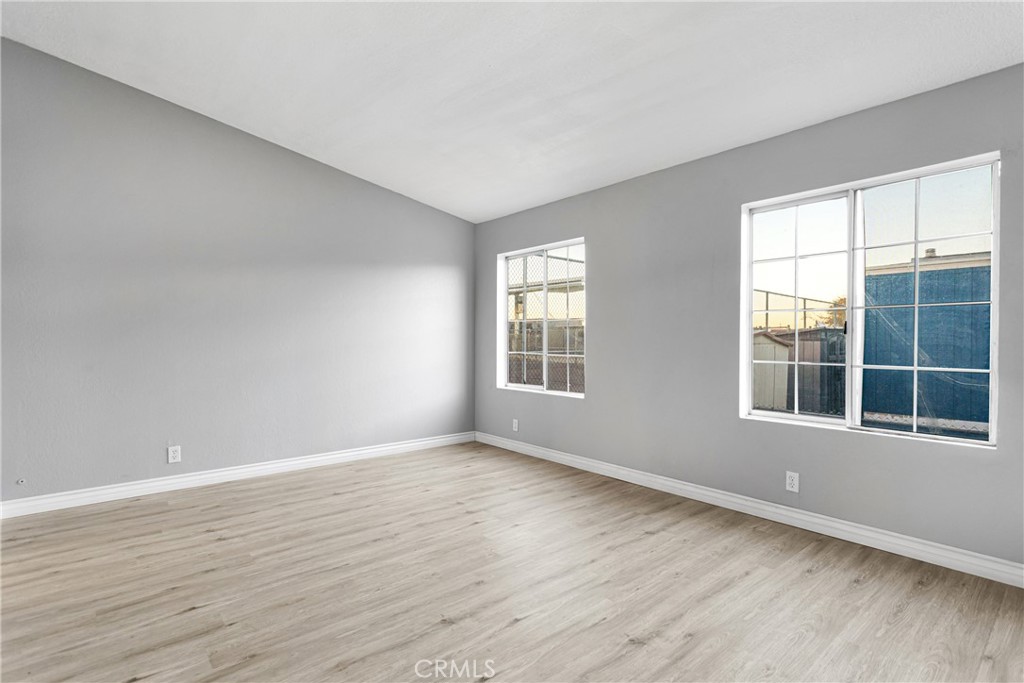 8450 G Avenue, Unit 63 Hesperia, CA 92345 - Photo 20 of 31 a view of an empty room with wooden floor and a window