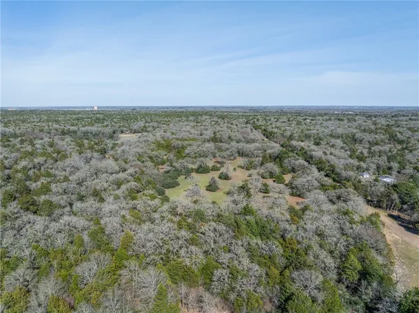 an aerial view of ocean with green space