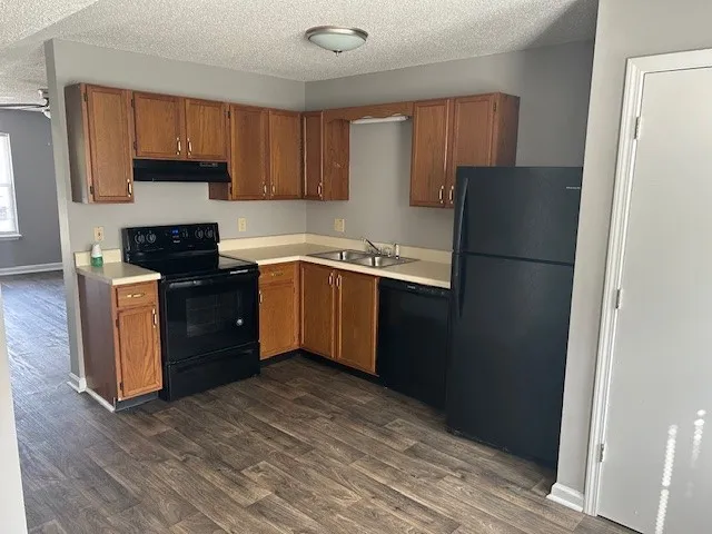 a kitchen with stainless steel appliances granite countertop a refrigerator stove top oven and sink