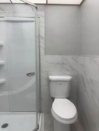 a white toilet sitting next to a bath tub