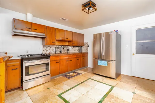 a kitchen with a refrigerator sink and cabinets