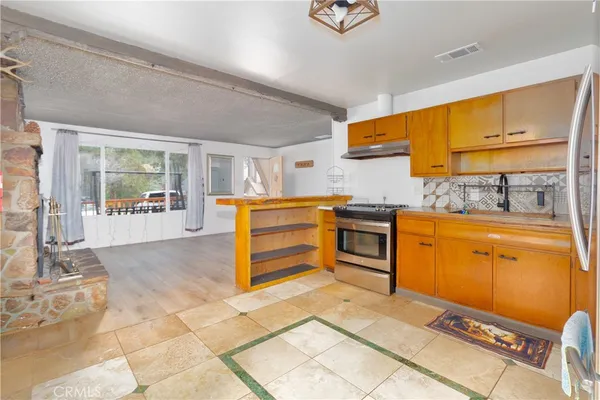 a kitchen with stainless steel appliances granite countertop a stove a sink and a refrigerator