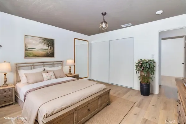 a bedroom with a bed and a potted plant