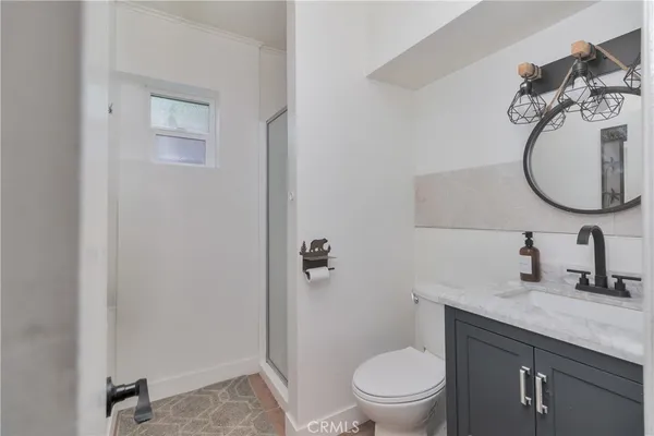 a bathroom with a granite countertop toilet sink and mirror