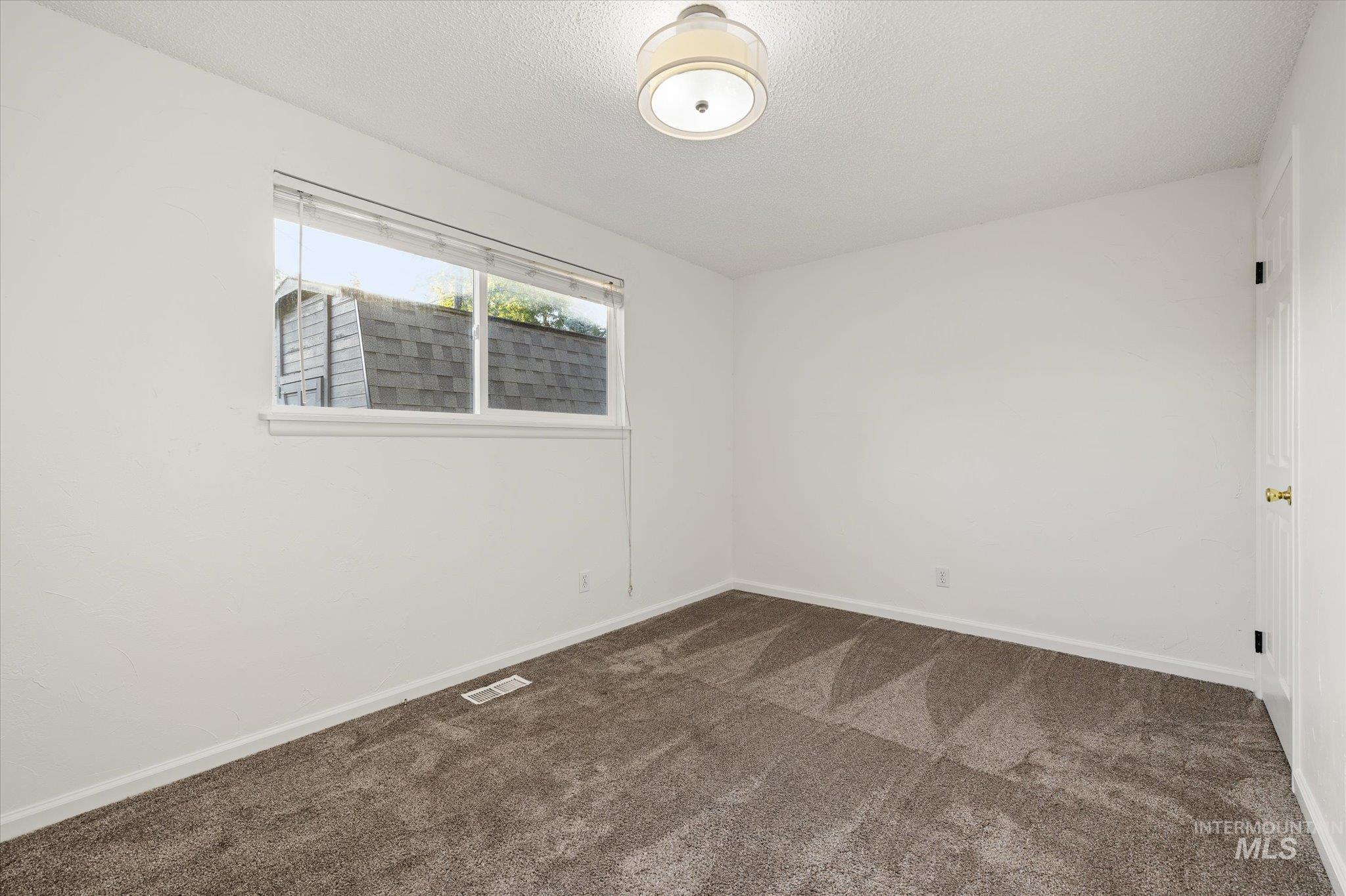2302 Pendleton Street Boise, ID 83705 - Photo 27 of 35 White-painted walls and trim complement the brown patterned carpeting