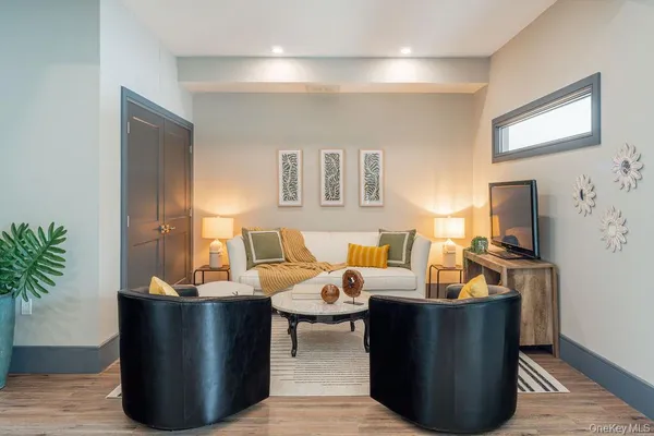 a living room with furniture a potted plant and a fireplace