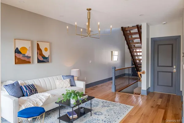 a living room with furniture a piano and a chandelier