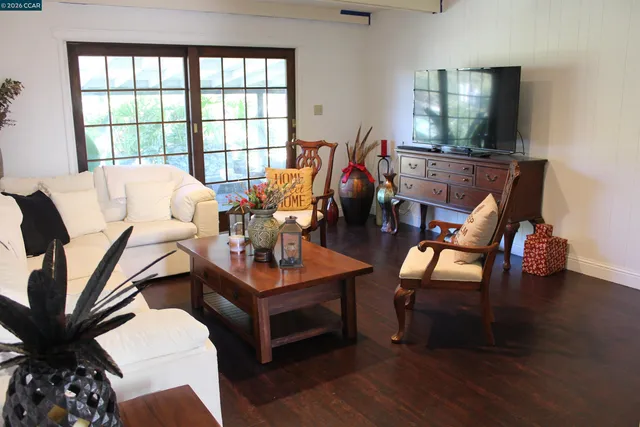 a living room with furniture and a large window with wooden floor