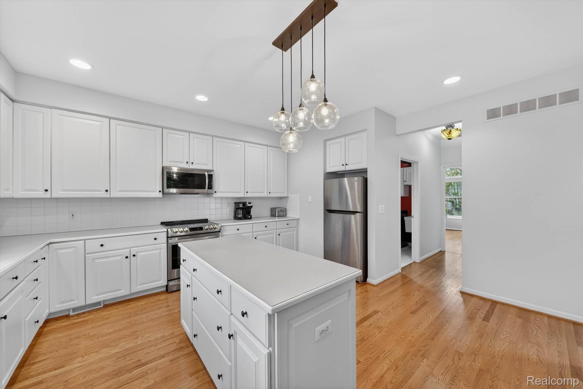 1112 Vernier Road Grosse Pointe, MI 48236 - Photo 14 of 39 Kitchen with white cabinetry, stainless steel appliances, light countertops, and light wood finished floors