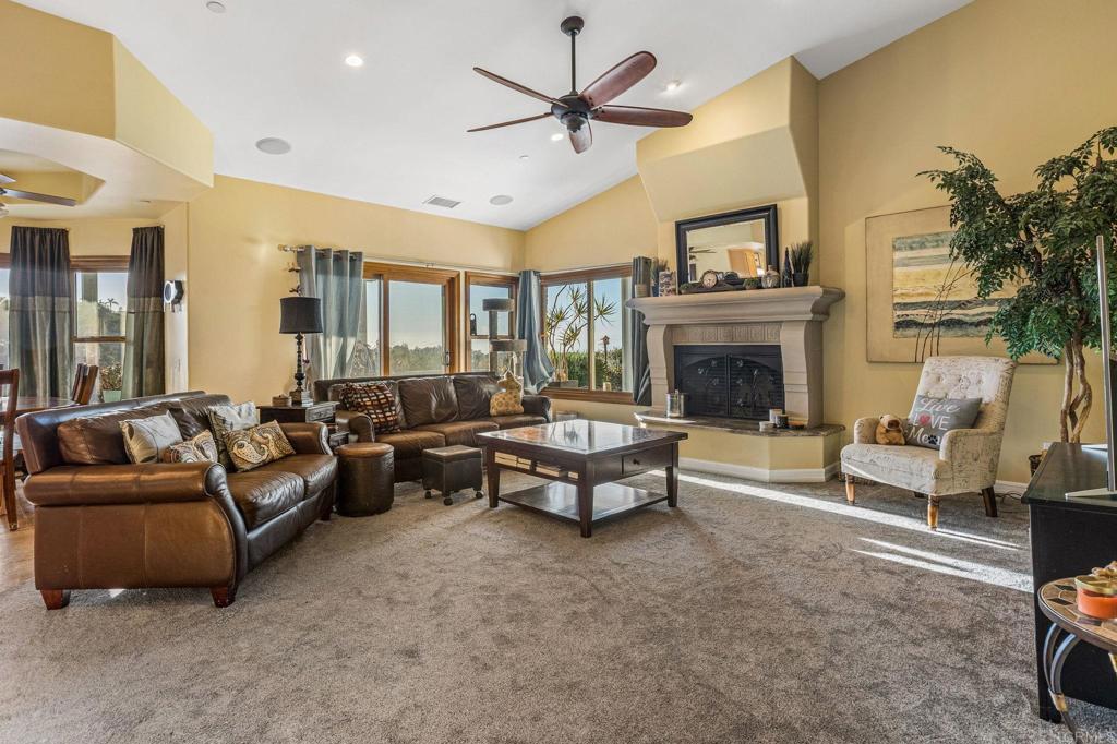 28623 Willow Park Road Escondido, CA 92026 - Photo 8 of 21 a living room with furniture a fireplace and a chandelier