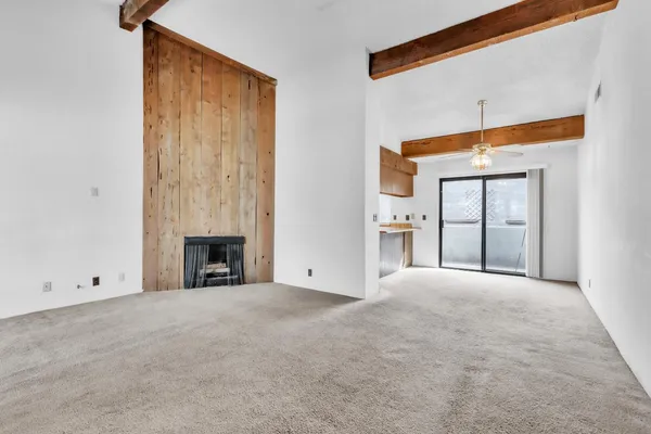a view of an empty room with chandelier and a window