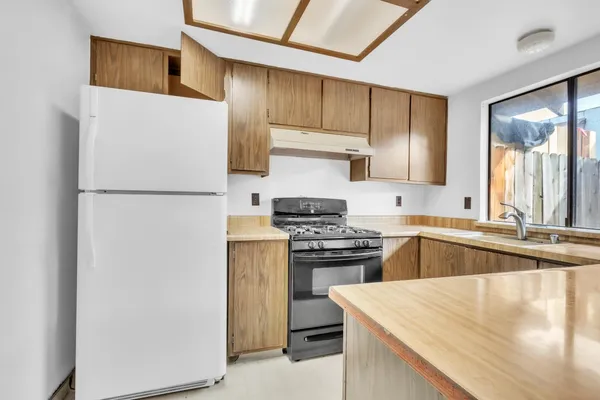 a kitchen with a stove a refrigerator and a sink