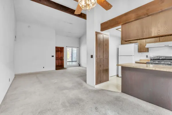 a view of kitchen with refrigerator and cabinets