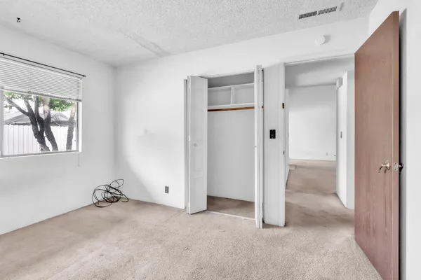 an empty room with a window and a livingroom