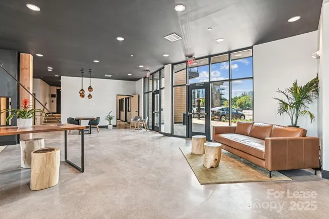 a living room with furniture a table and kitchen view