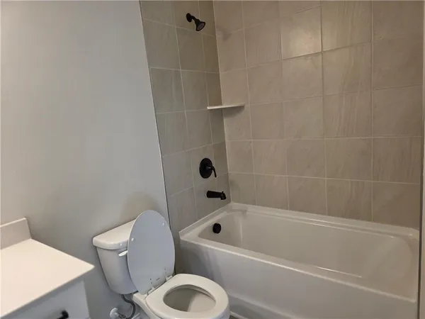 a bathroom with a toilet and a bath tub