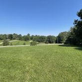 a view of a green field with wooden fence