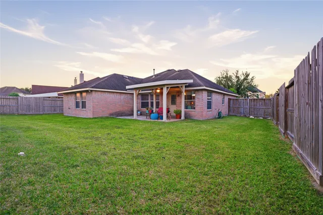 a view of a patio with couple of chairs and a potted plant