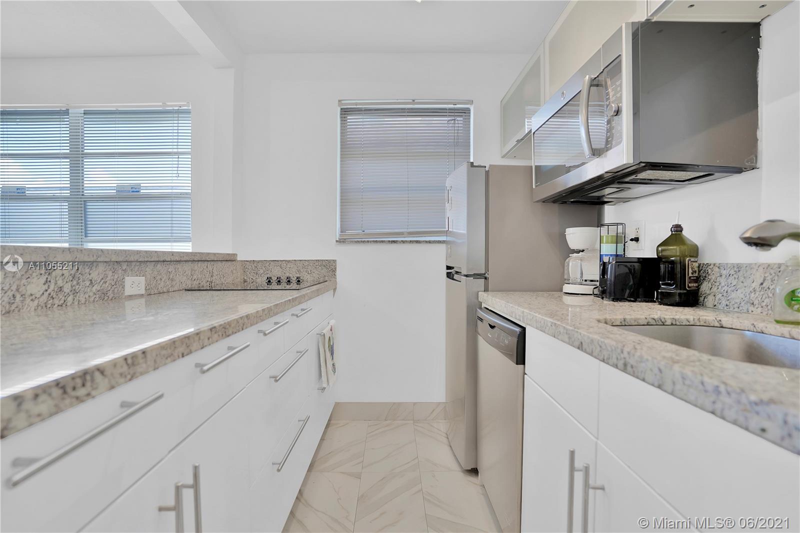 734 Meridian Avenue, Unit 4 Miami Beach, FL 33139 - Photo 4 of 12 a kitchen with stainless steel appliances granite countertop a sink and a stove
