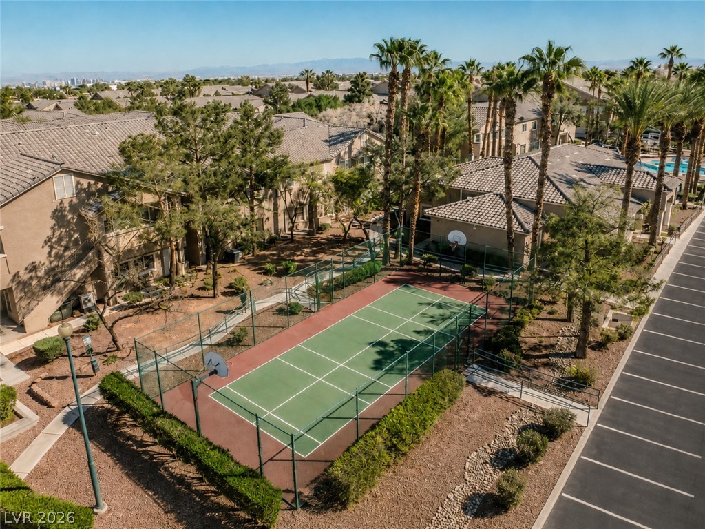 2153 Quarry Ridge Street, Unit 103 Las Vegas, NV 89117 - Photo 38 of 42 An aerial view showcases a vibrant community basketball court amidst lush landscaping and residential buildings.
