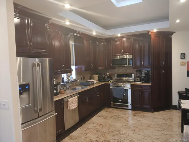 a kitchen with stainless steel appliances granite countertop a refrigerator a sink and a stove