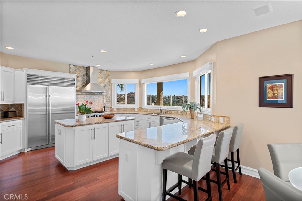 4 Via Goleta San Clemente, CA 92673 - Photo 21 of 70 a kitchen with granite countertop a table chairs refrigerator and microwave