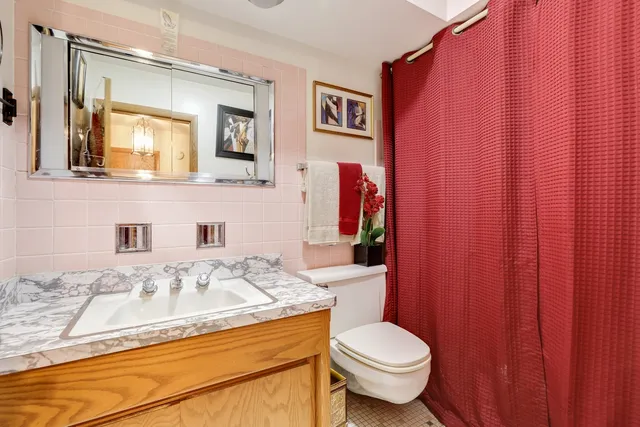 a bathroom with a granite countertop sink mirror vanity and toilet
