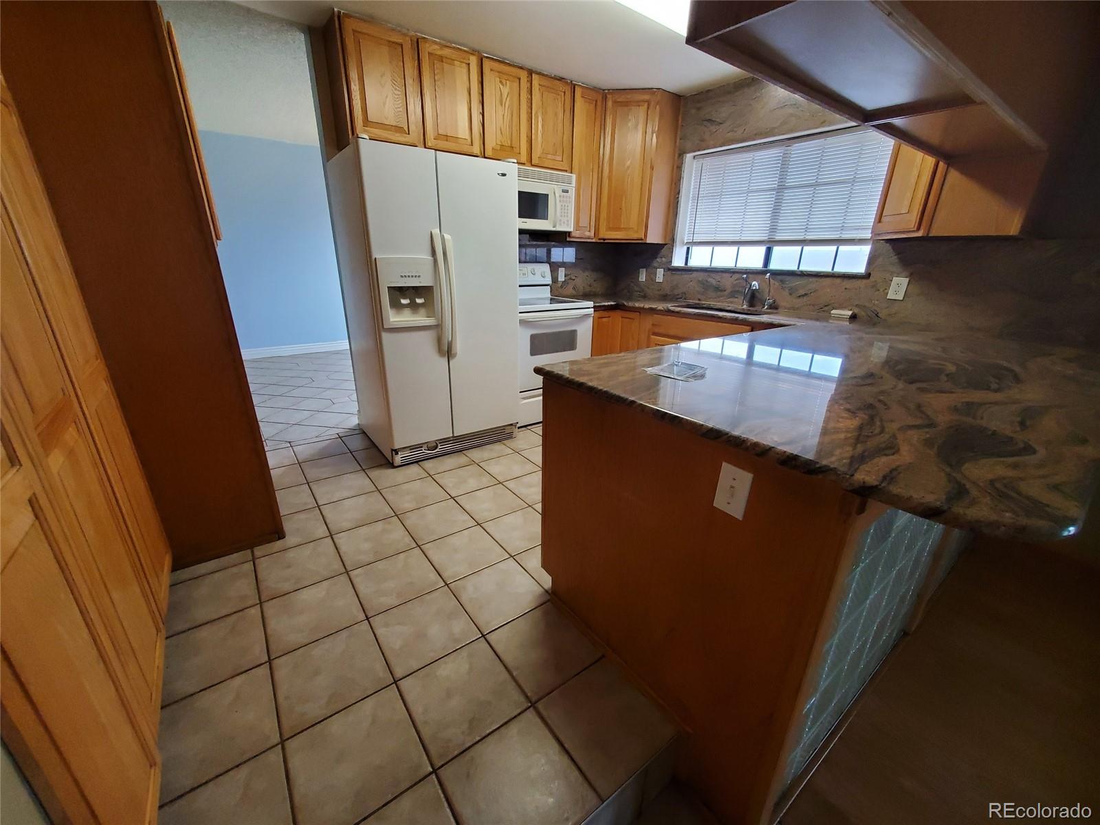 Undisclosed Address Broomfield, CO 80023 - Photo 17 of 25 a kitchen with a sink a refrigerator and cabinets