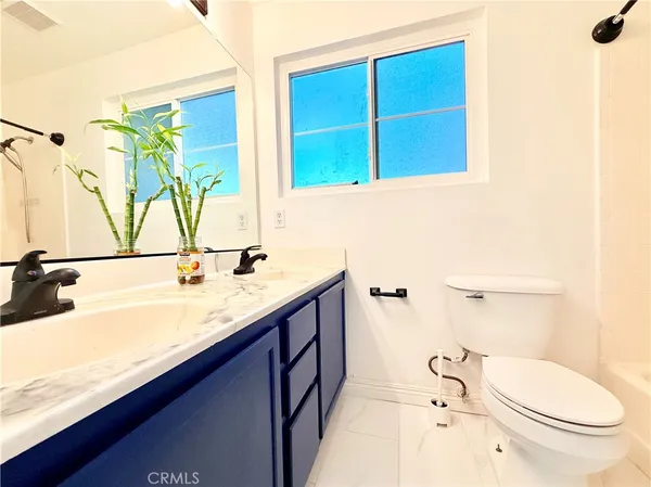 a bathroom with a granite countertop sink mirror vanity and toilet