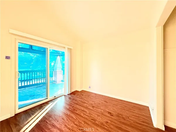 a view of a room with wooden floor and a floor to ceiling window